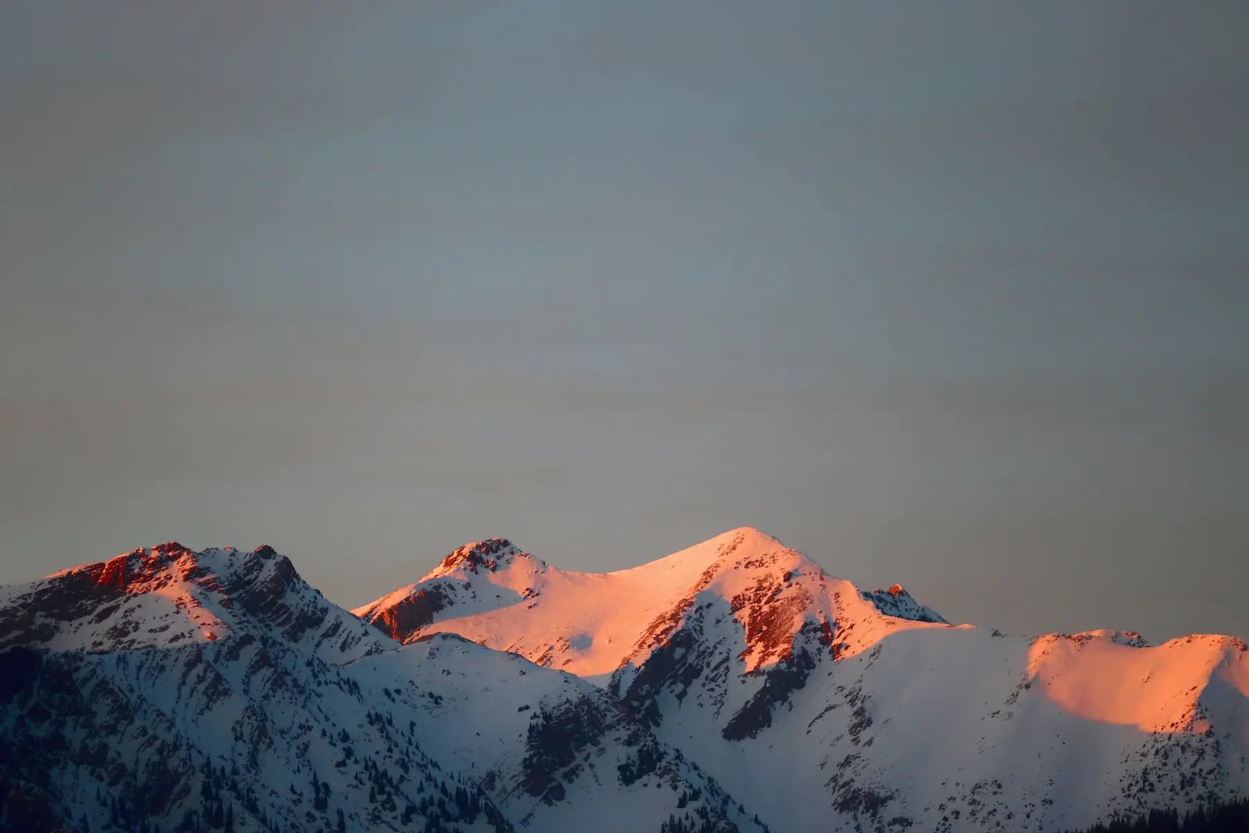 Moody sunrise over snow-covered peaks